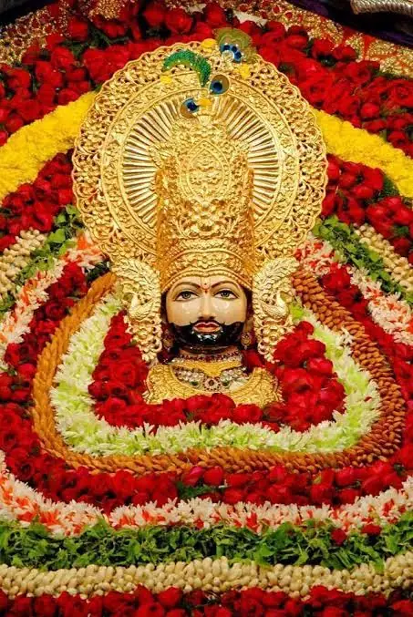 Shri Khatu Shyam Ji in a golden crown, adorned with red roses and flower garlands