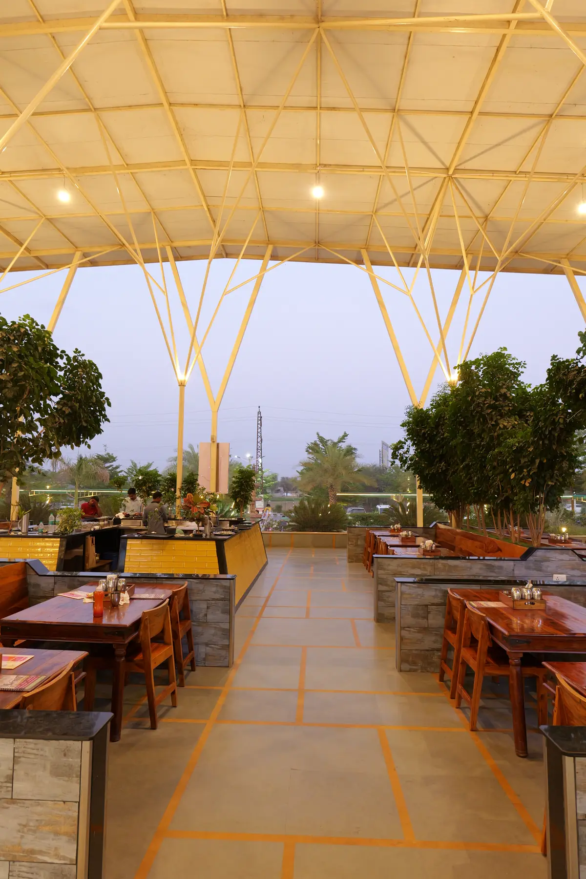 Restaurant tables under the canopy lit up in the evening