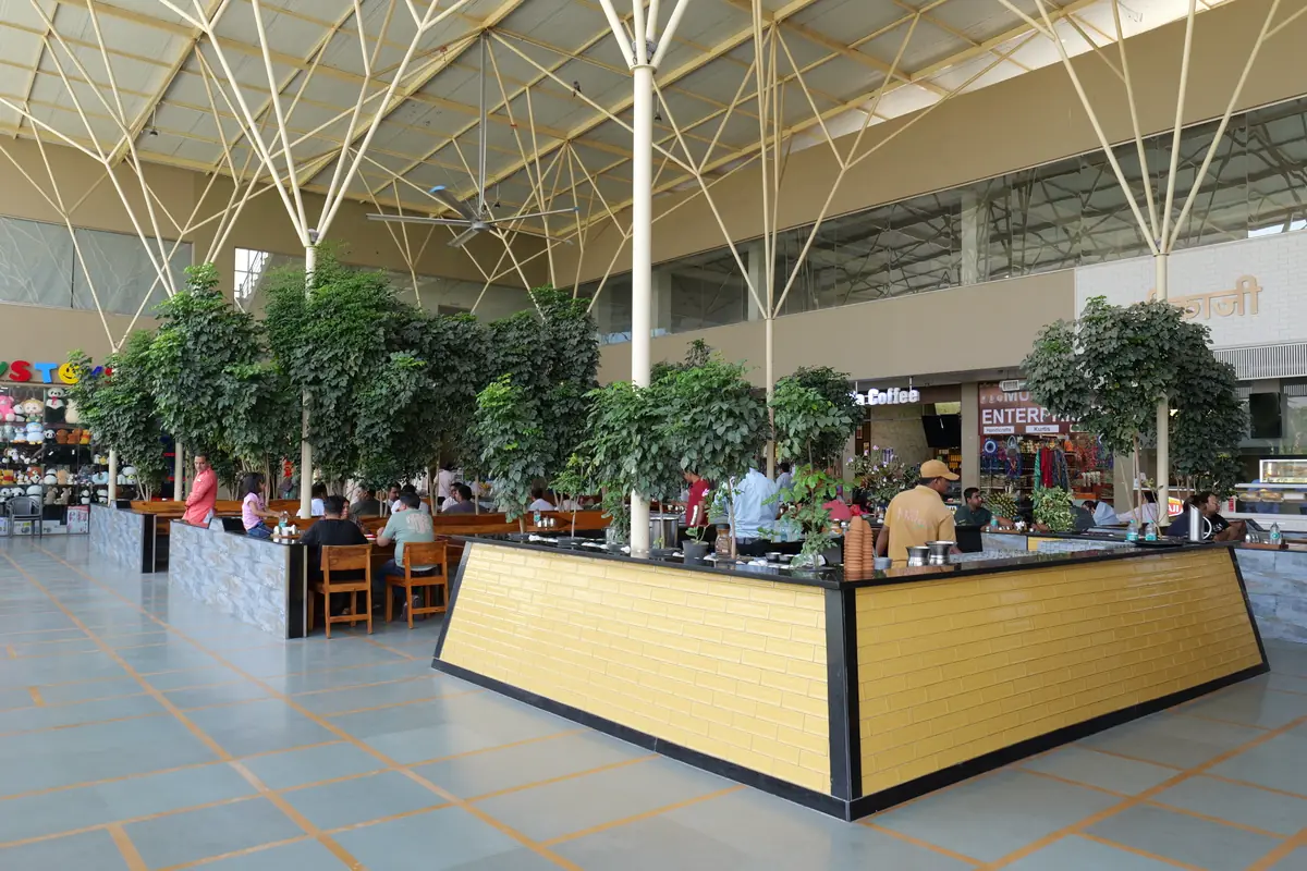 Open-air food court with a live counter under the steel canopy