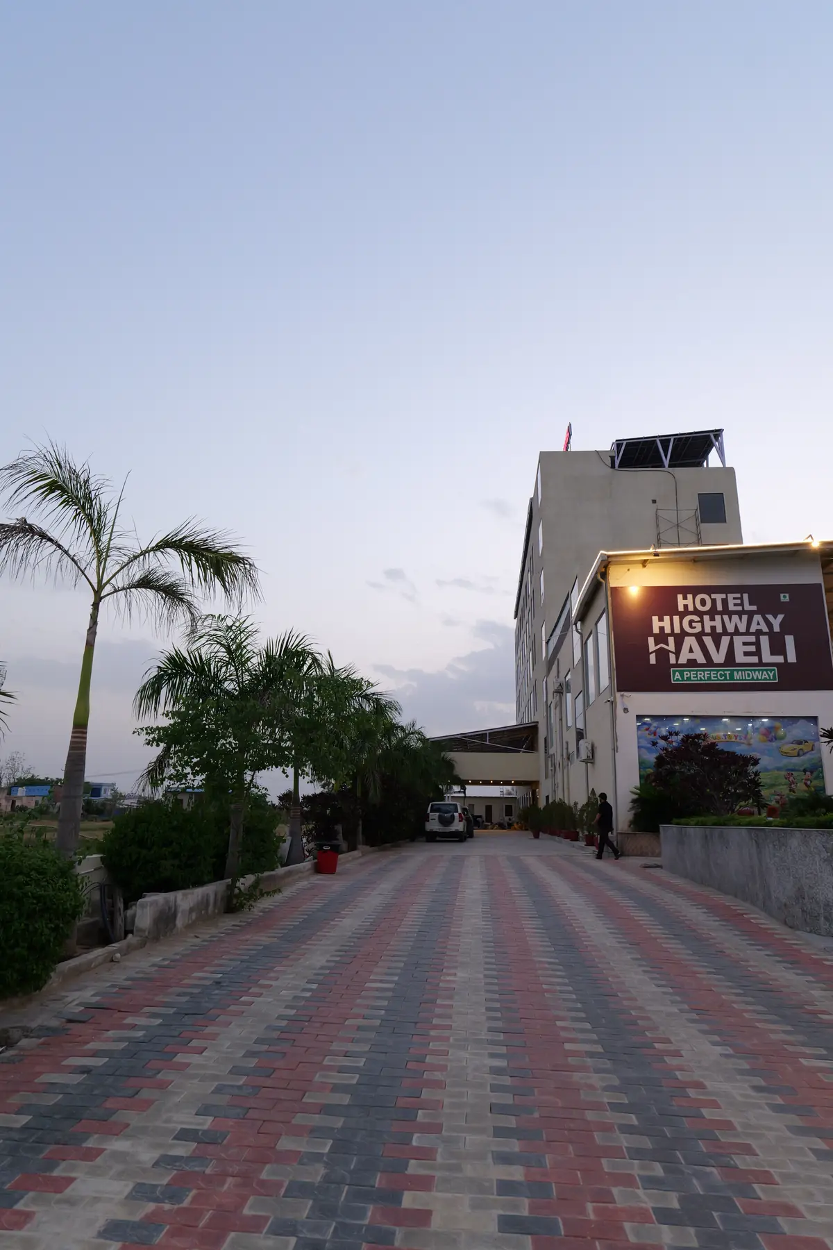 Hotel Highway Haveli entrance and driveway at dusk