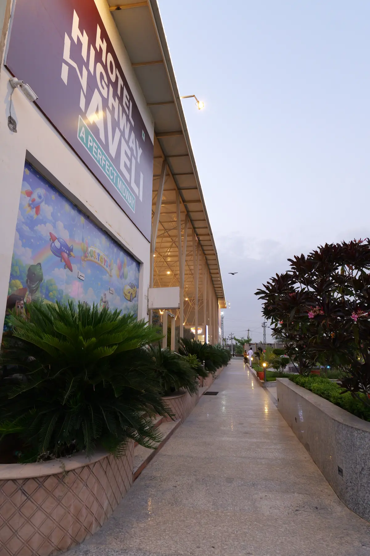 Landscaped walkway along the building at dusk